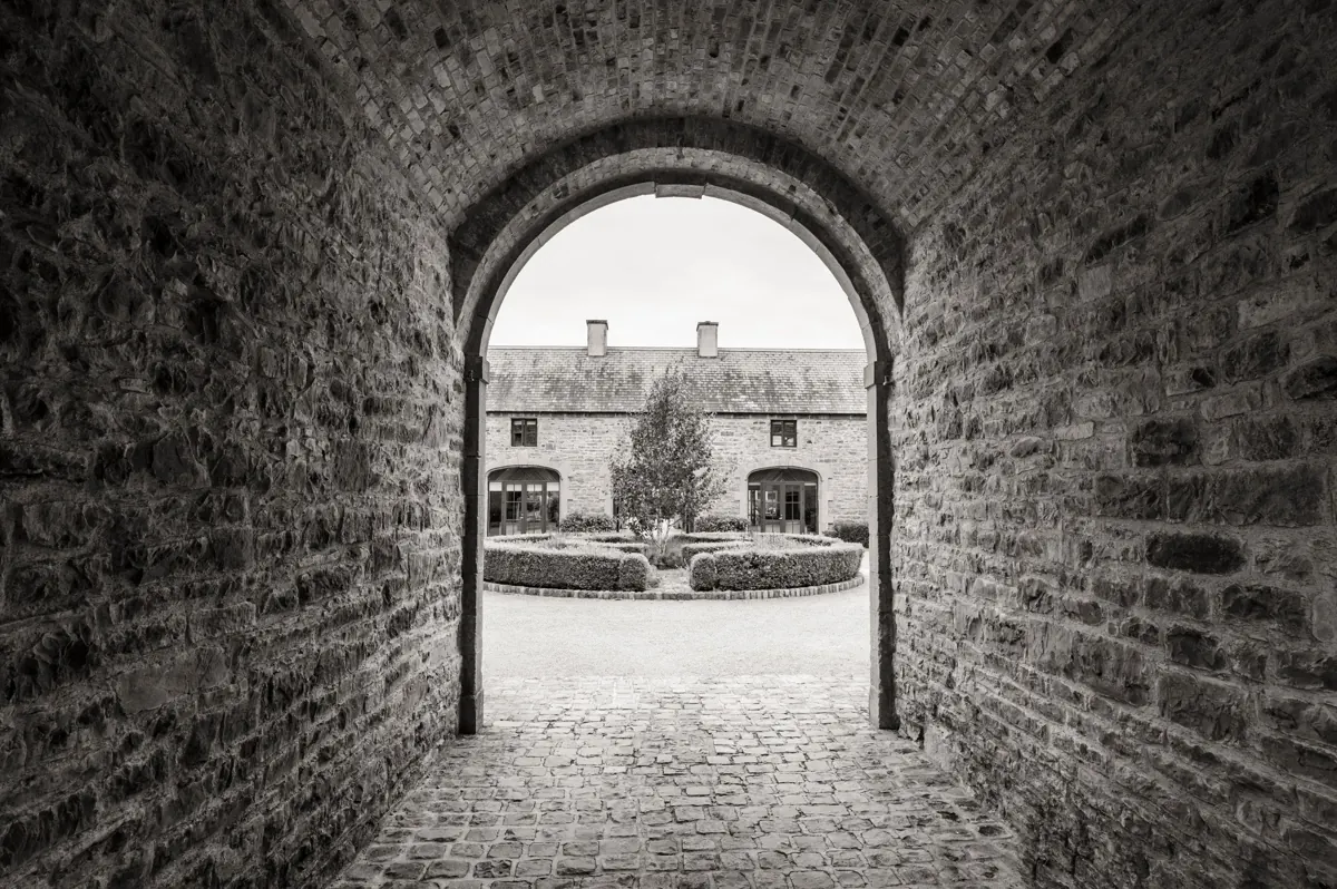 Clonabreany House courtyard seen through a stone archway.