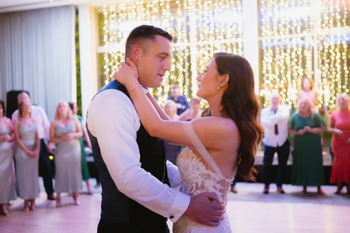 The couple dancing together in front of the hanging lights