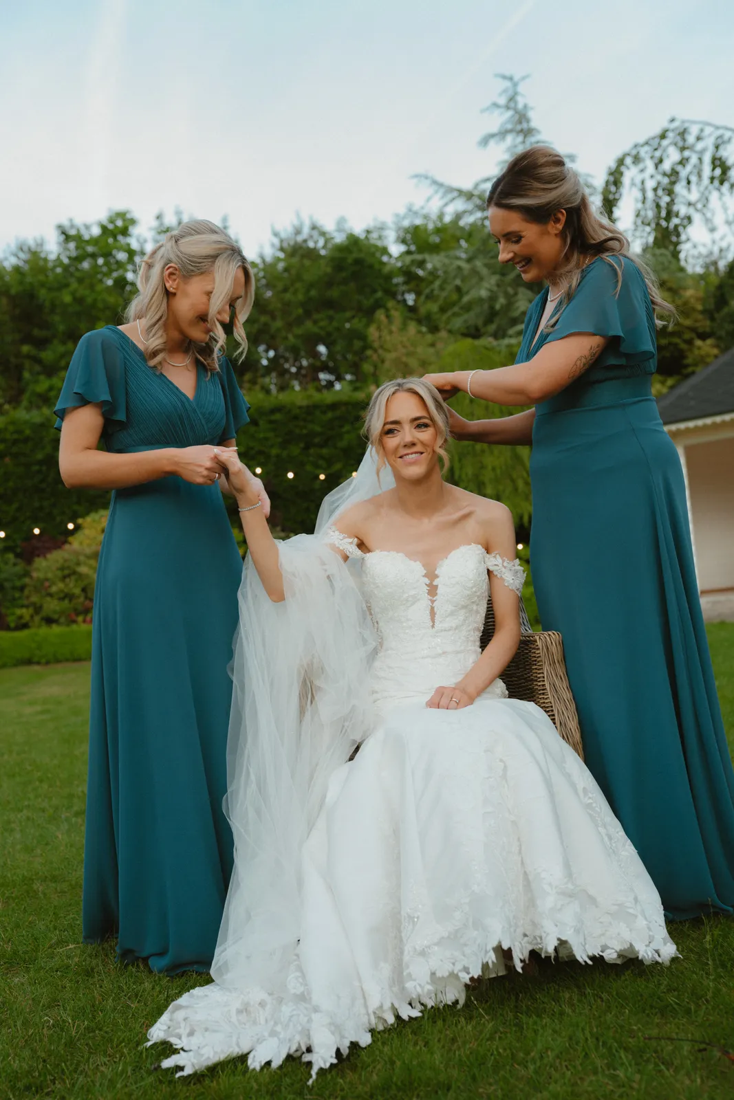 Hazel seated with women in teal dresses
