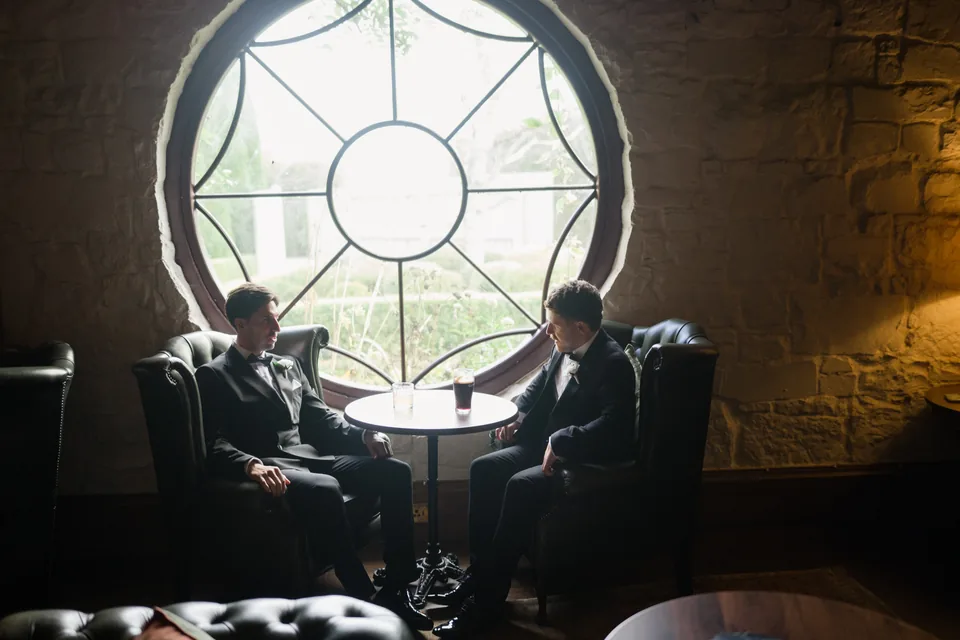Jay sits beside the circular window in the stone-walled room.