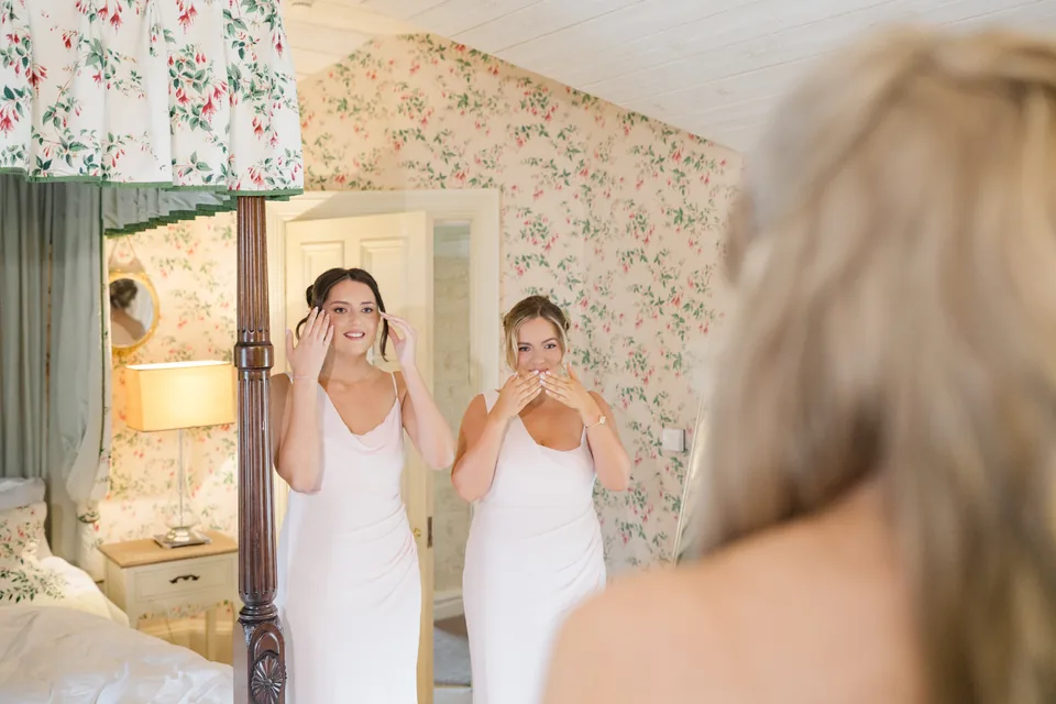 Bridesmaids react as they see the bride.