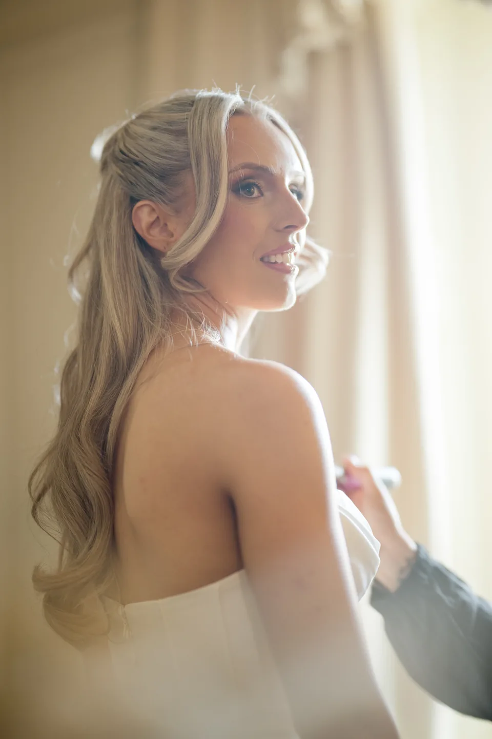 Soft backlight and veil create a delicate bridal portrait.
