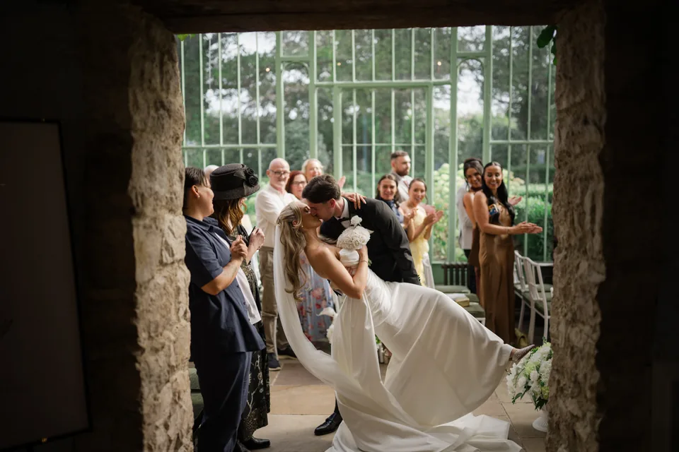 A playful ceremony exit framed by the dark stone doorway.