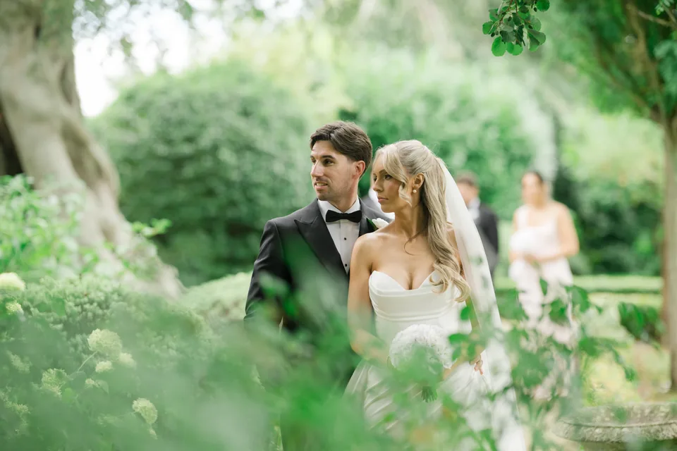 Foreground foliage creates depth around the couple.
