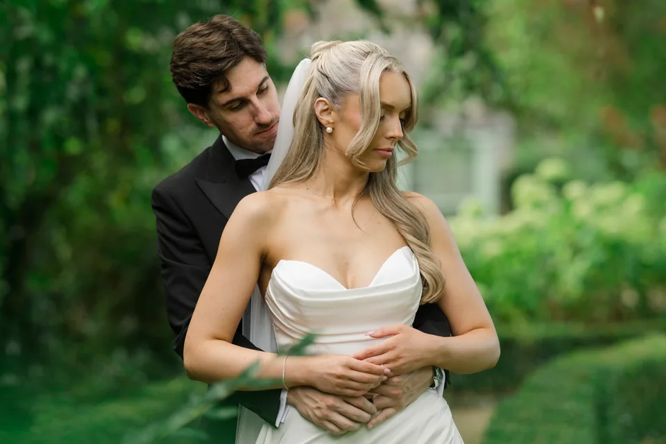 A close embrace surrounded by green foliage.