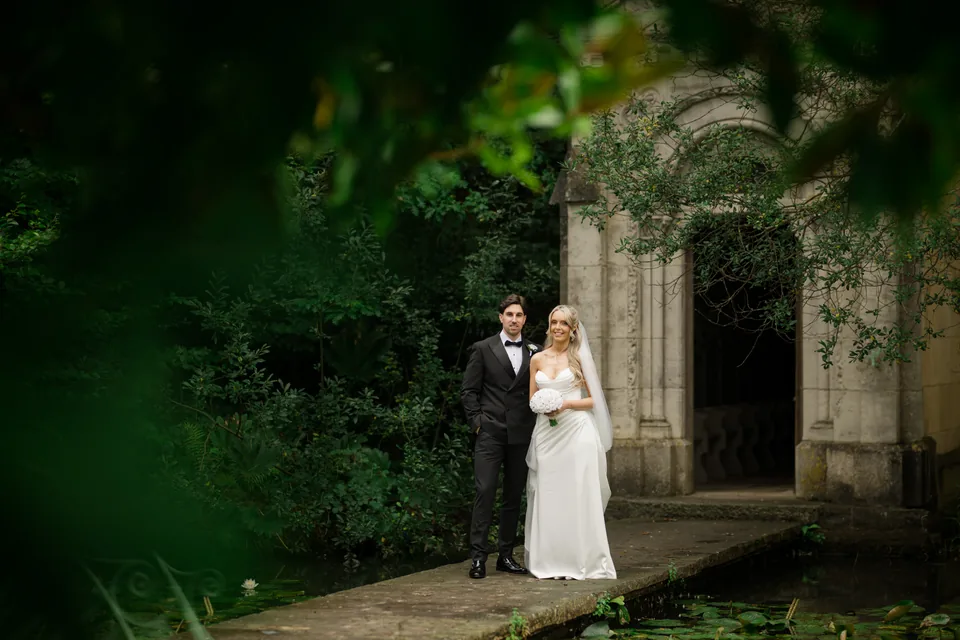 The garden arch and dark foreground foliage create a portrait.