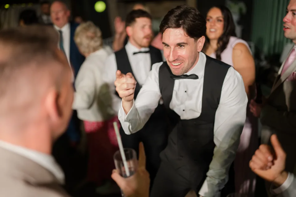 Jay joins the crowd with a lively dance-floor expression.