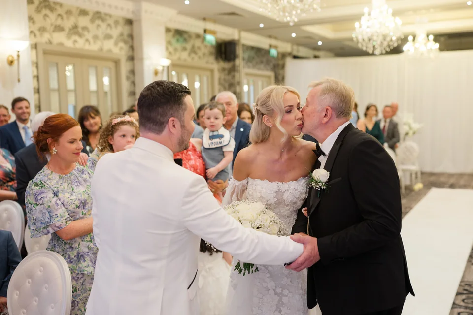 Ieva greeting her father beside Darren during their hotel ceremony