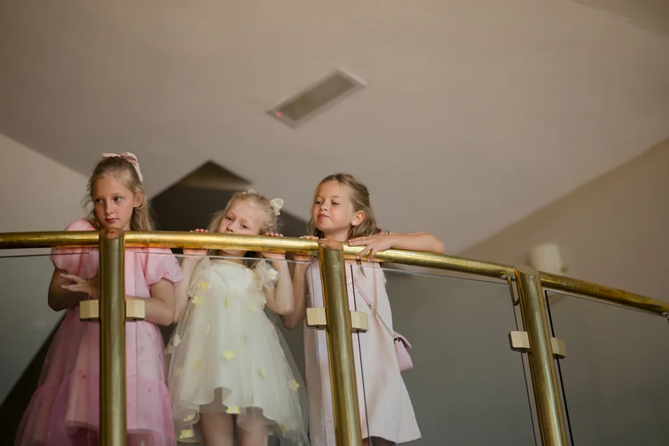 Three children watching from the curved landing at Ieva and Darren’s wedding