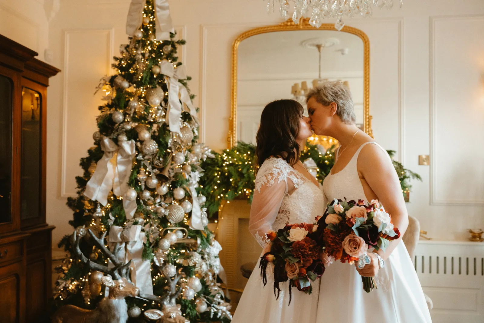 The couple kiss by the Christmas tree