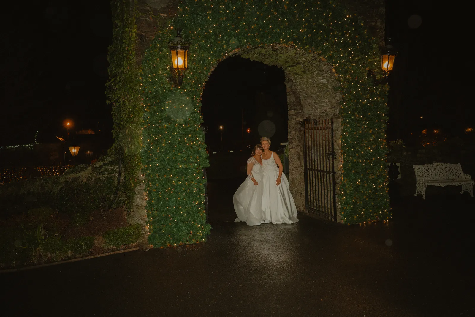 Jenny and Orla-Marie stand beneath an illuminated stone arch at Darver Castle.