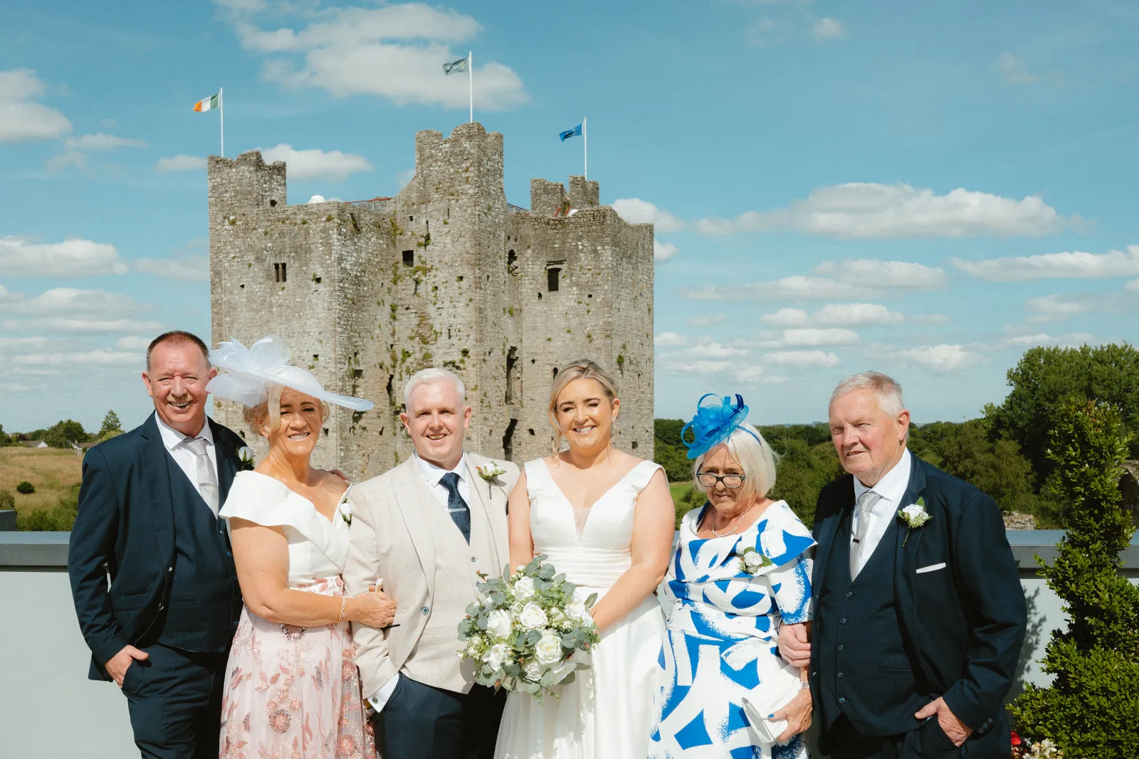 The couple with guests and the castle behind