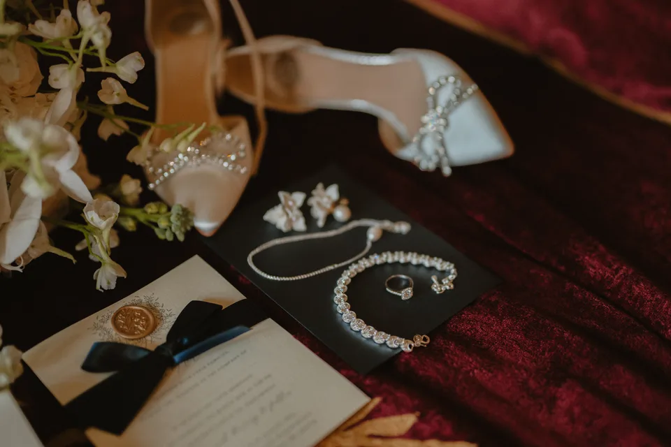 Lynsey’s wedding shoes, jewellery and flowers arranged on patterned fabric.