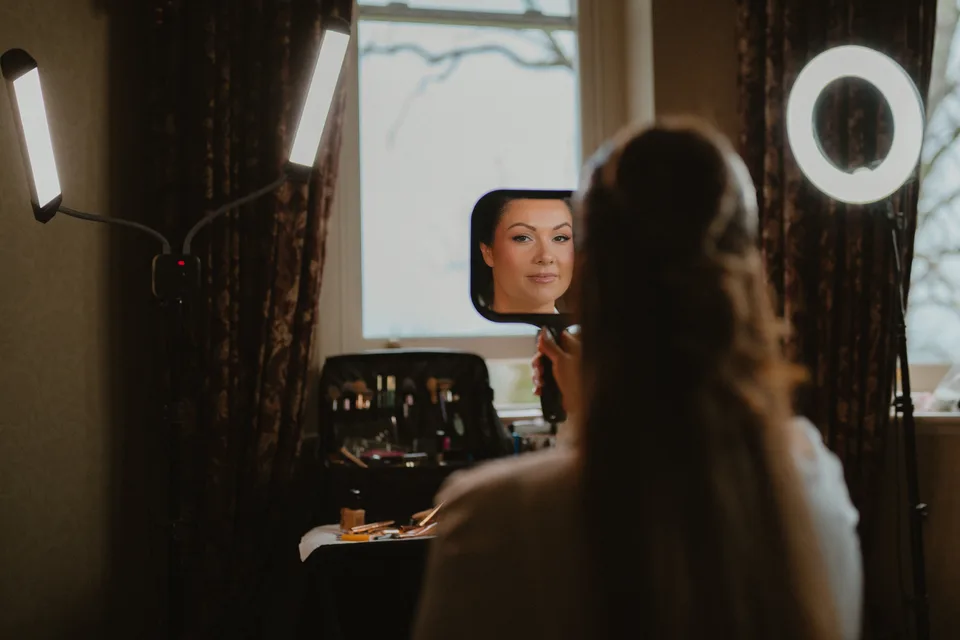 Lynsey’s make-up reflected in a mirror during wedding preparations.