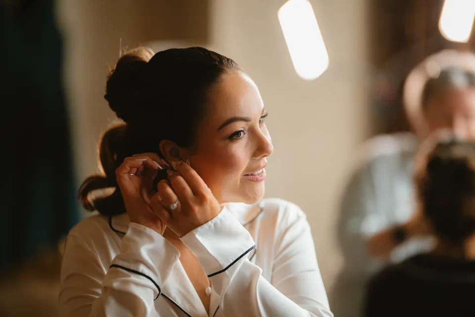 Lynsey fastening an earring before the ceremony.
