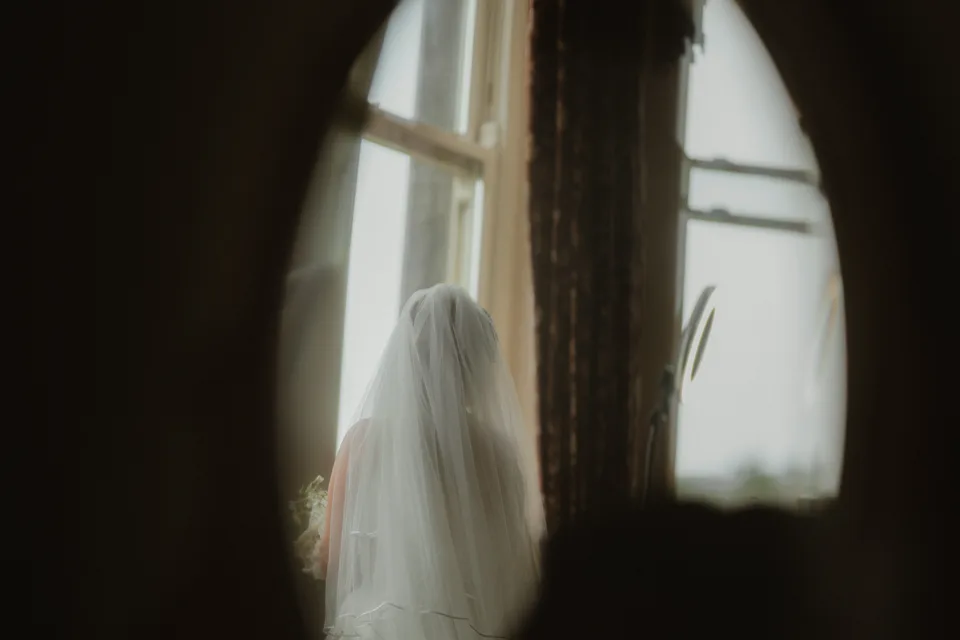 Lynsey’s veil and silhouette reflected near the bedroom window.