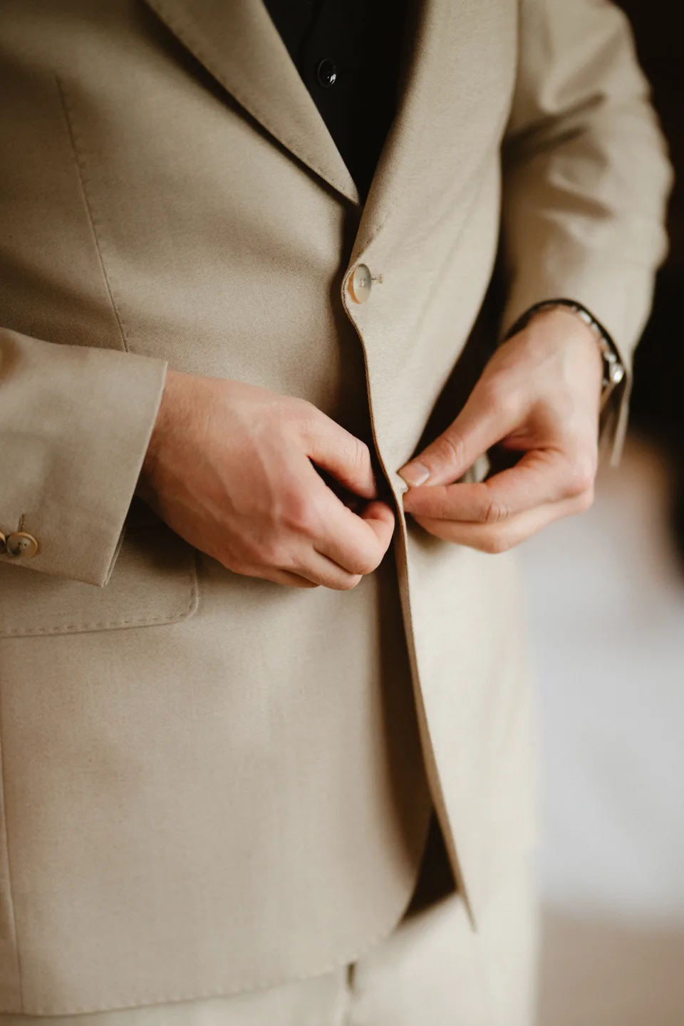 Jamie buttoning his wedding jacket.