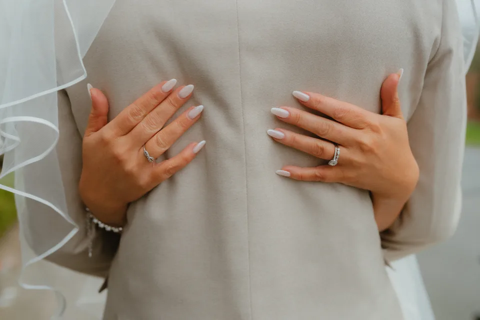 Lynsey’s hands resting on Jamie’s jacket beneath her veil.