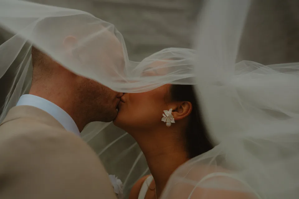 Lynsey and Jamie kissing beneath the veil at Kilronan Castle.