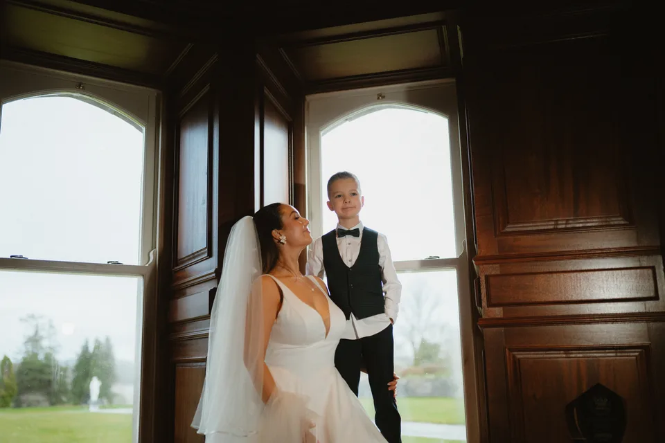 Lynsey with a young wedding attendant in the light of the castle windows.