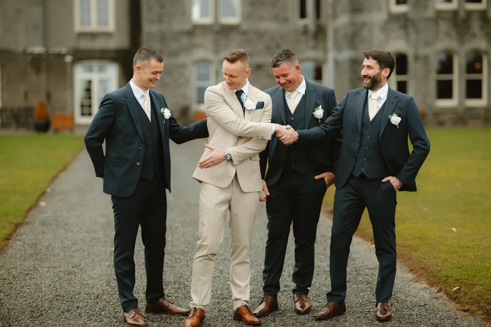 Jamie and his wedding party walking together outside Kilronan Castle.