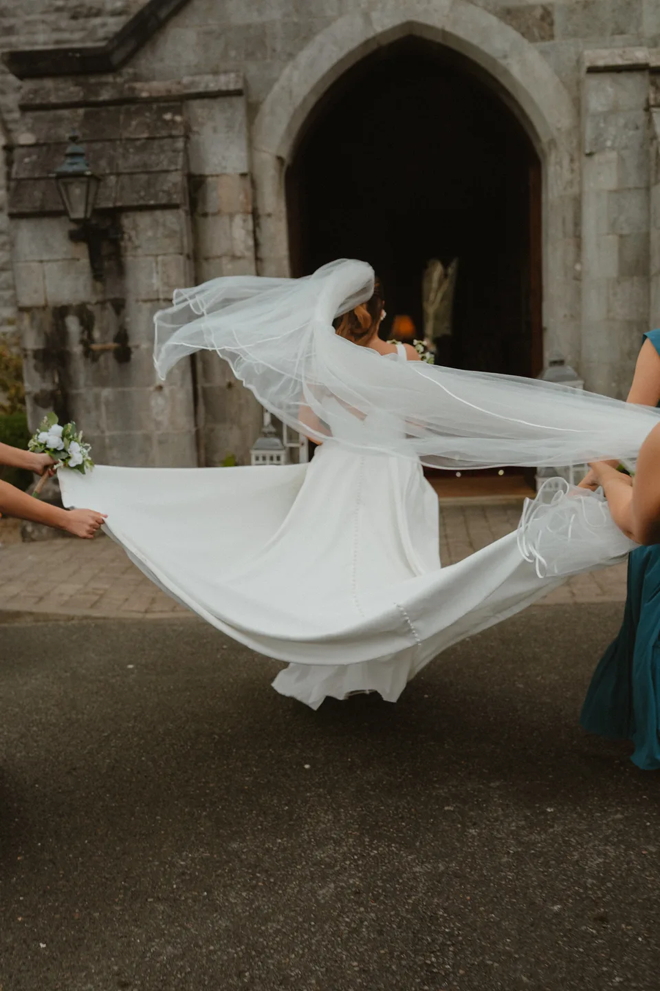 Lynsey spinning her wedding dress outside the stone castle entrance.