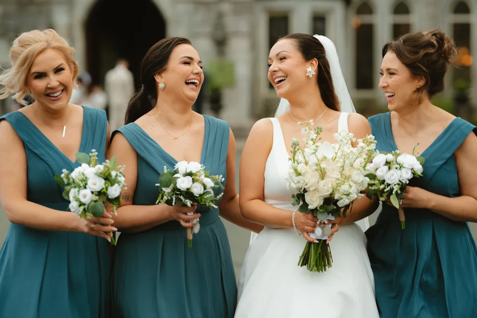 Lynsey laughing with her bridesmaids in their teal dresses.