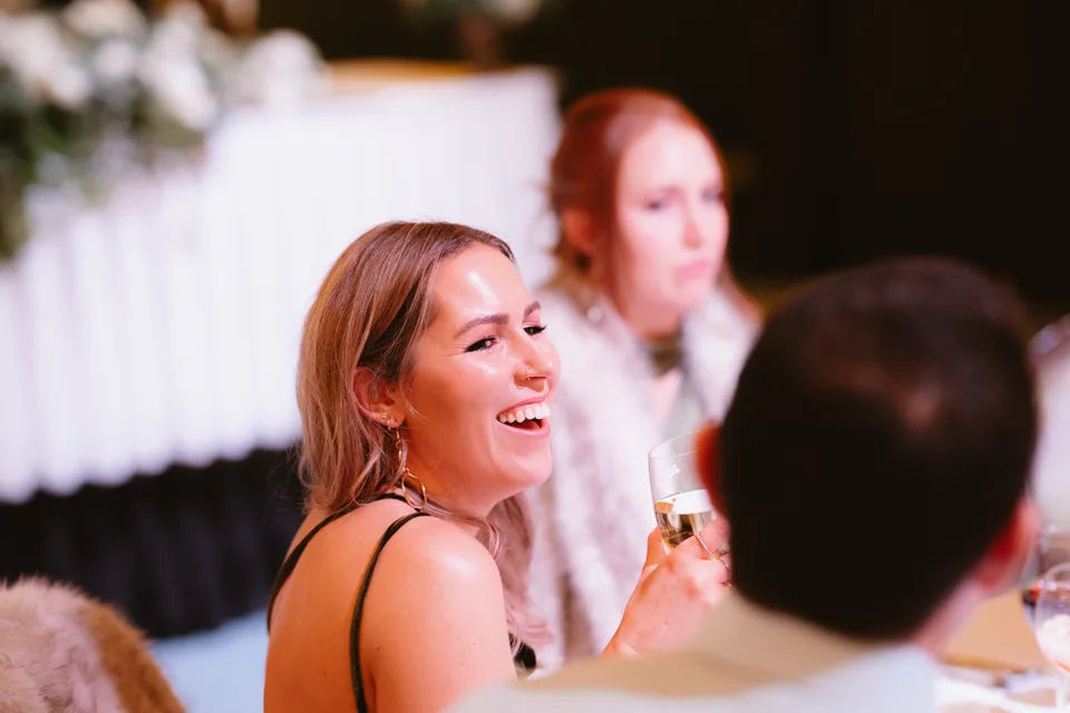 A guest laughing at the wedding reception table.