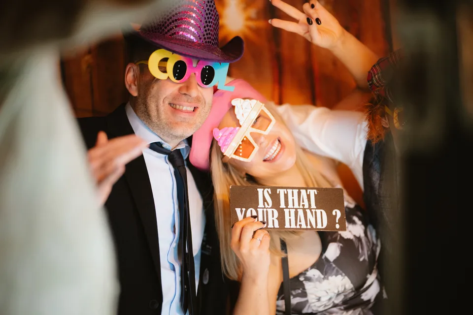 A guest in colourful party glasses and a hat during the evening celebrations.