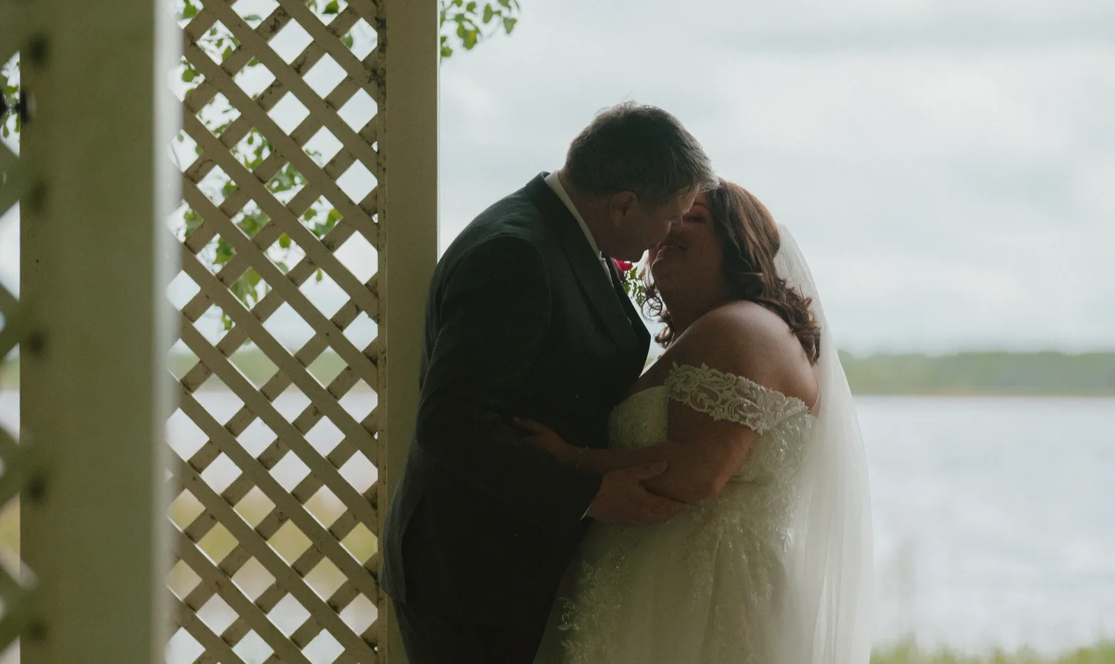 Michelle and Ray standing close beside the lake