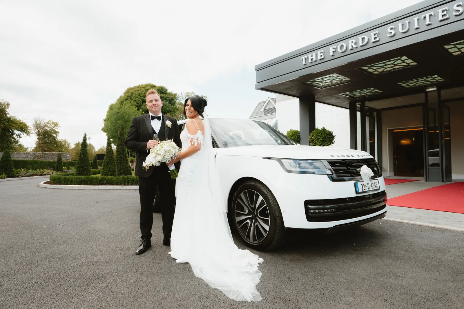 The couple beside the car at the hotel