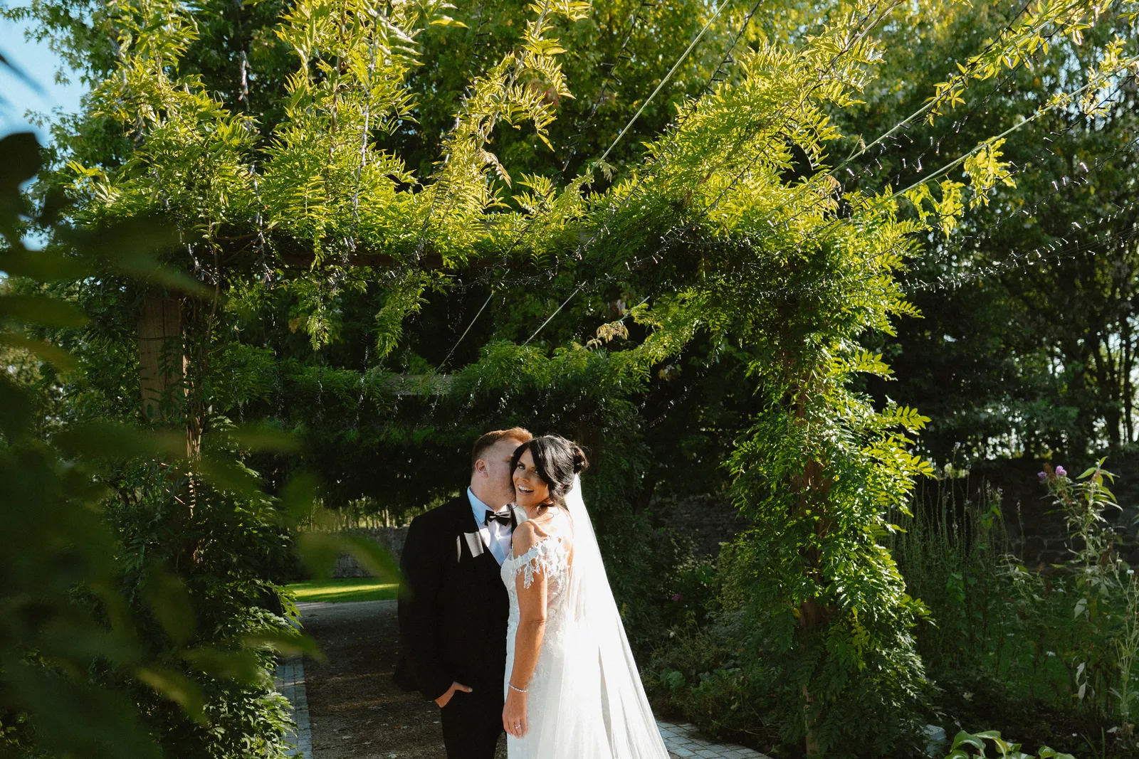 Nicola and Ciaran beneath a leafy garden canopy at The Johnstown Estate