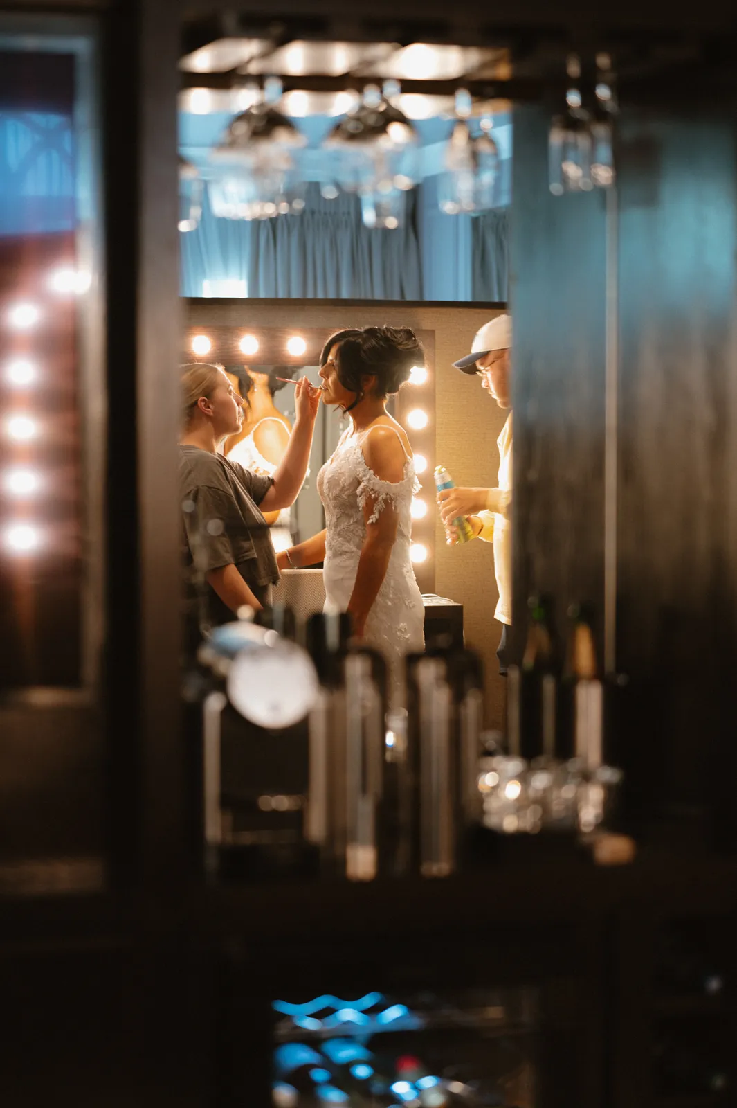 Nicola and Ciaran seen through a doorway in a warmly lit blue room with a chandelier and candles.