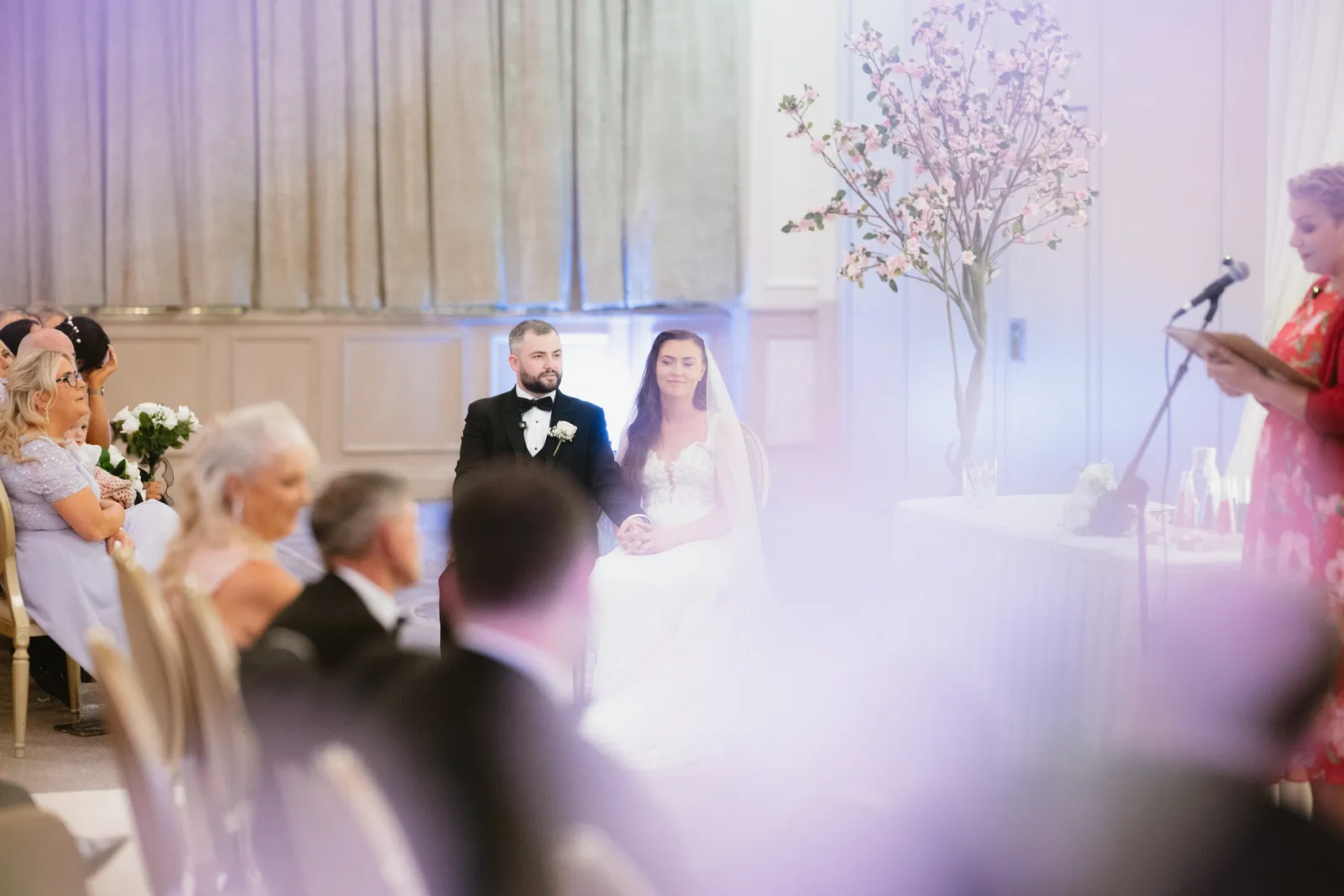Wide view of Nicola and Lee seated during the ceremony