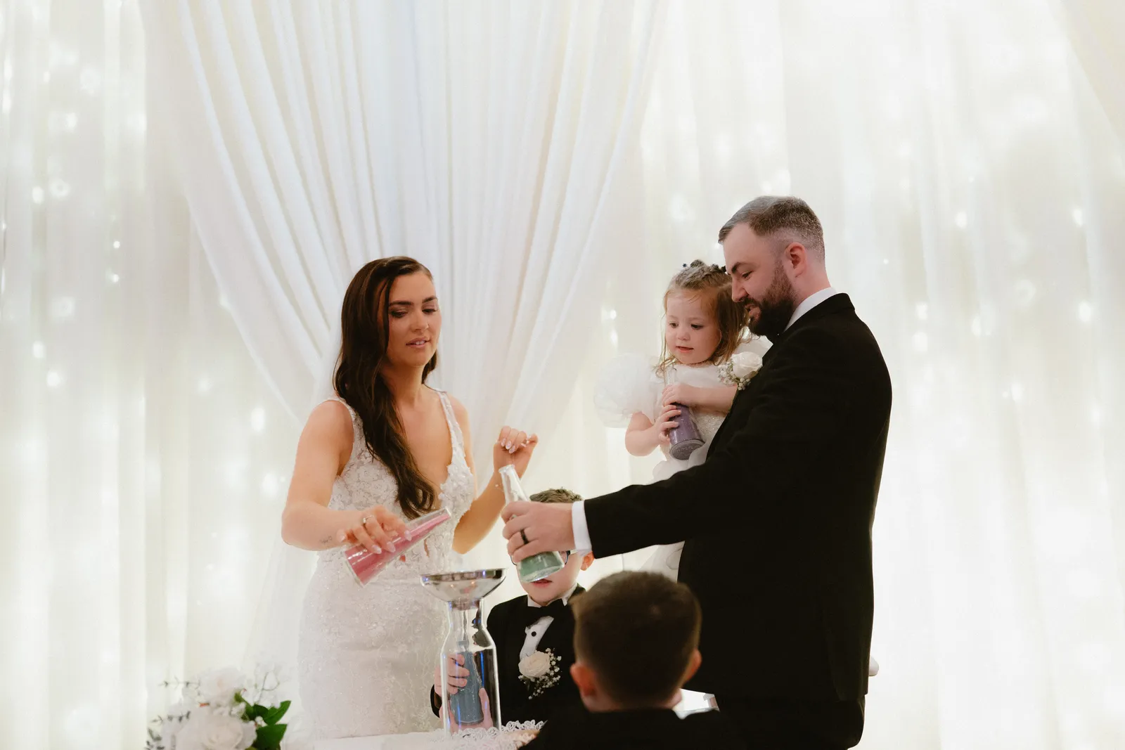 Nicola and Lee with a young guest at the sand ceremony