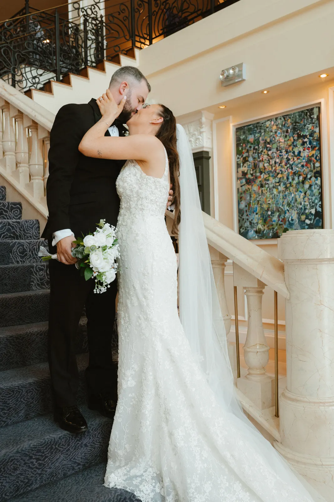 Nicola and Lee kissing beside the staircase