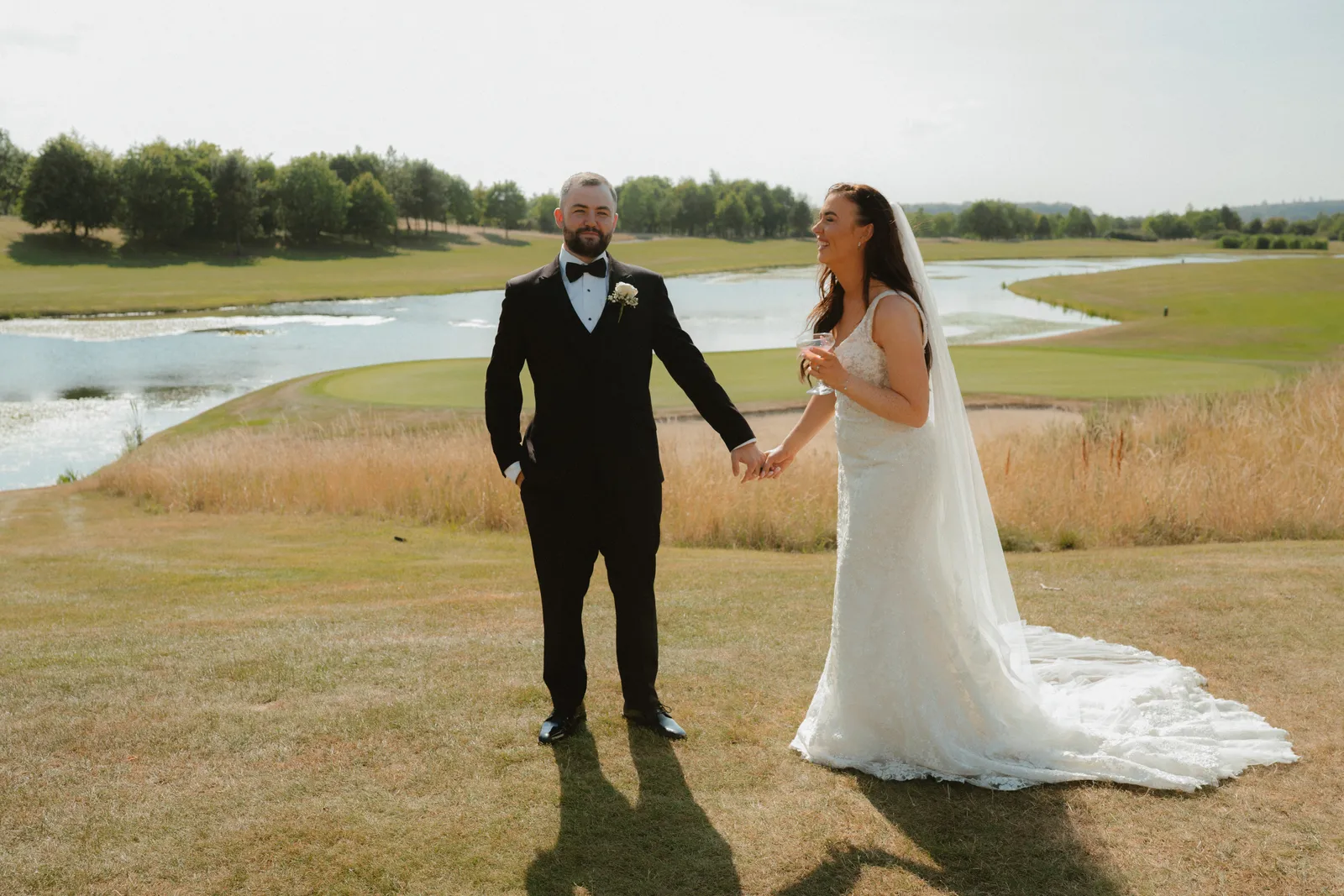 Nicola and Lee holding hands beside the water at The Heritage