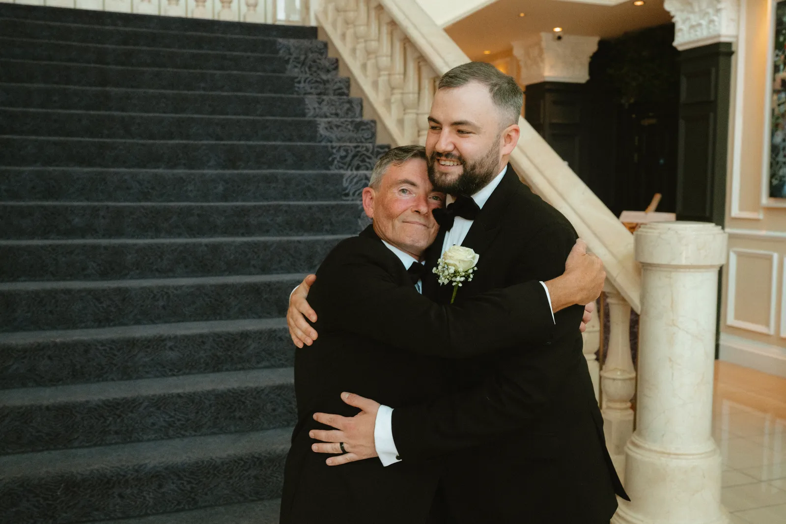 Lee embracing a guest on the stairs
