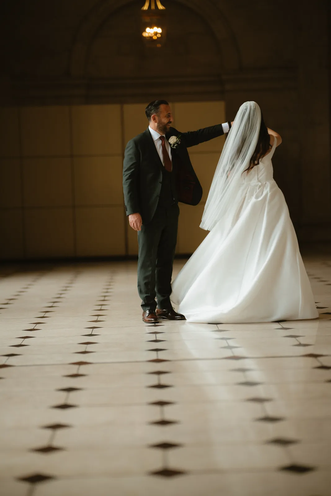 The couple stand together in the hall