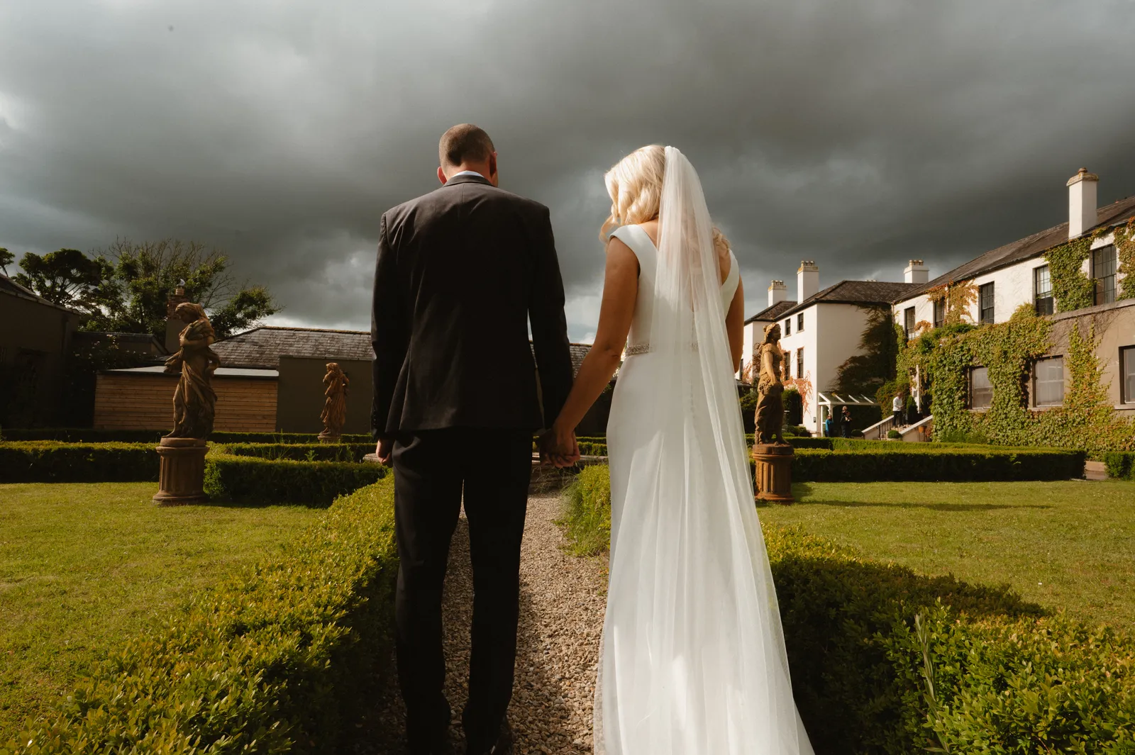 The couple holding hands on the lawn