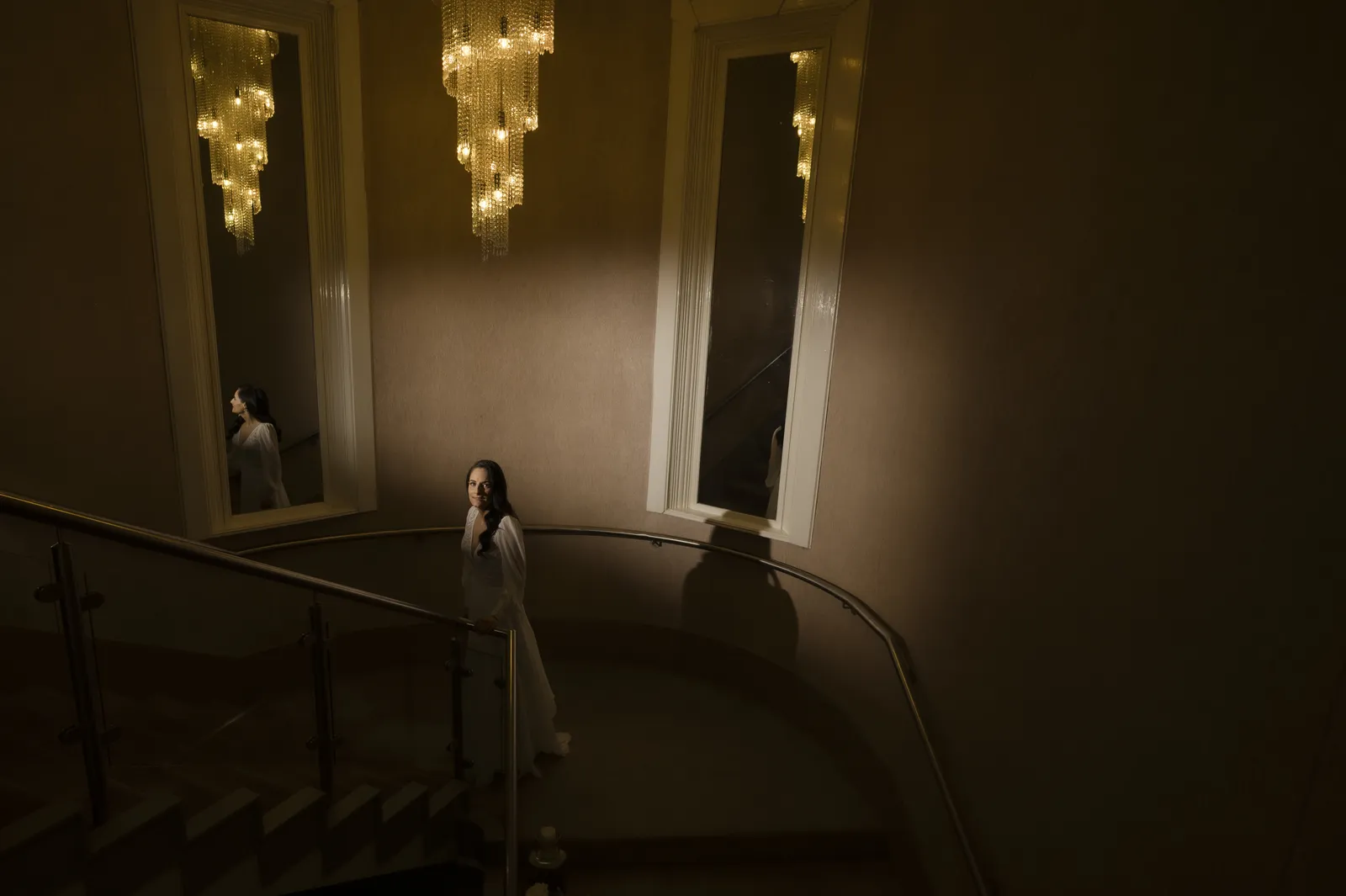 Roisin beneath chandeliers on the staircase