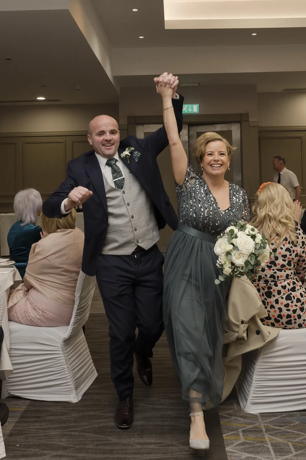 The couple entering with raised hands