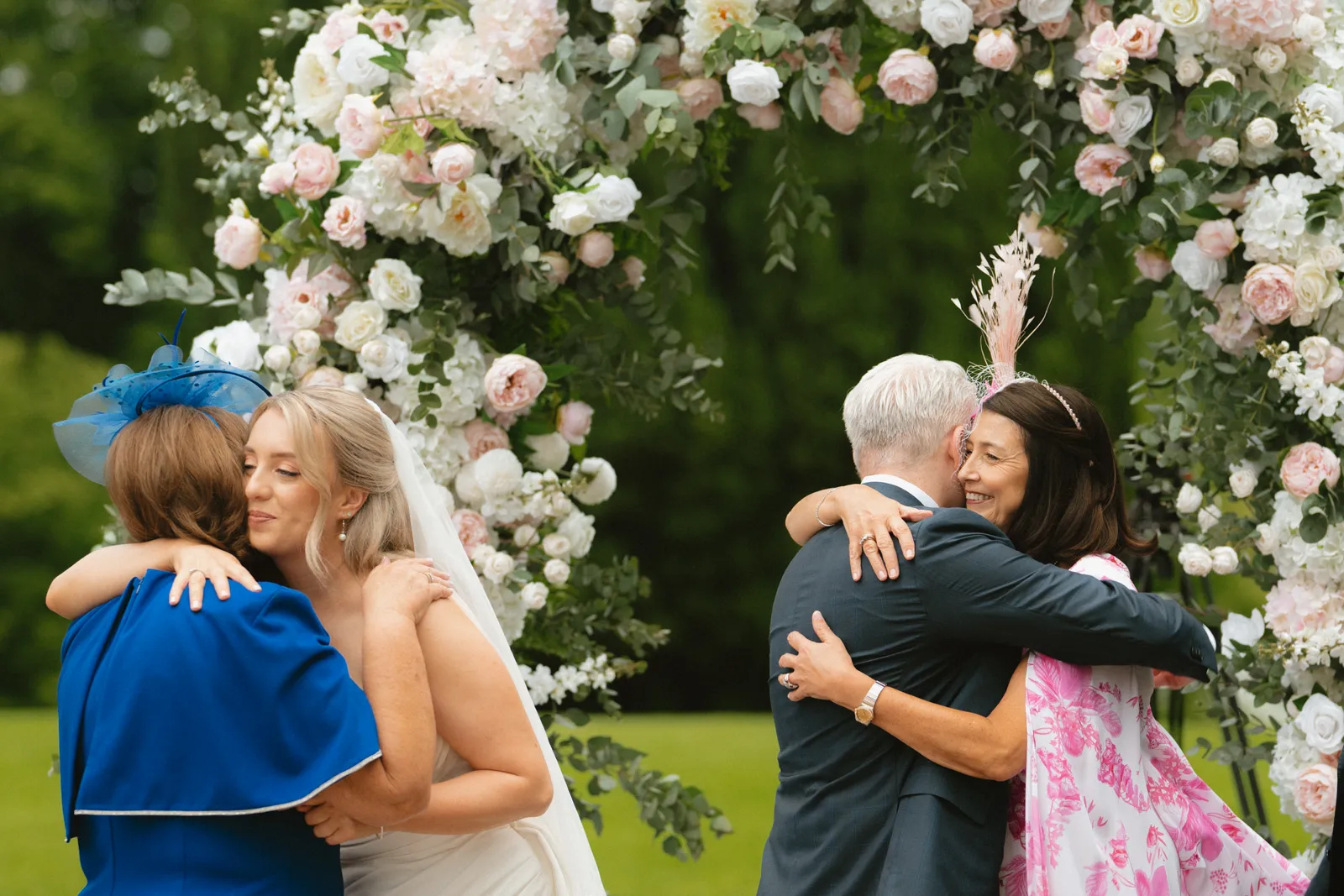 Embraces beneath the floral arch