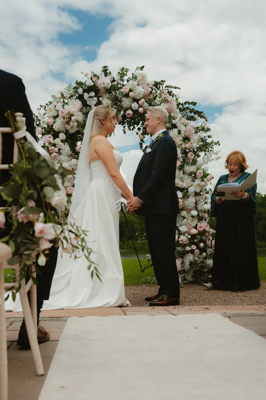 Roslyn and Jack leaving beneath the floral arch