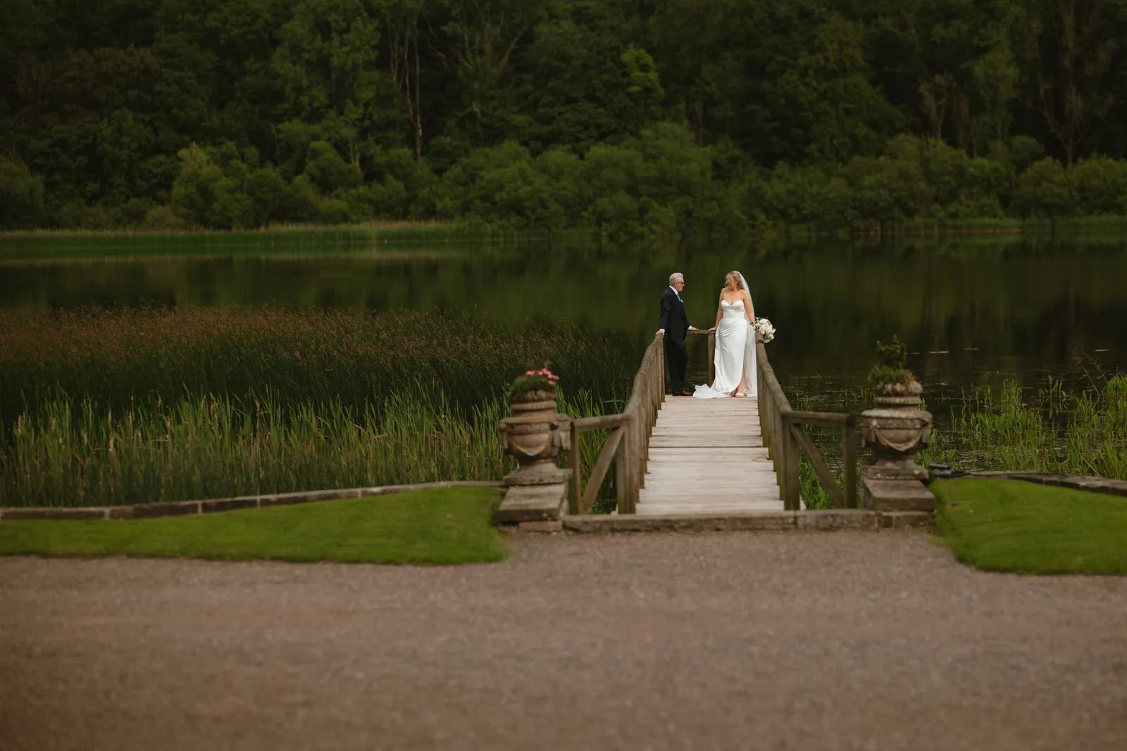 Roslyn and Jack on the lakeside bridge at Castle Leslie