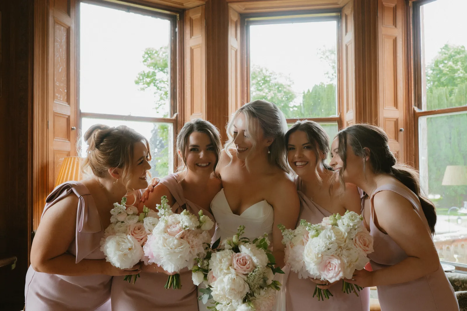 Roslyn laughing with women holding bouquets