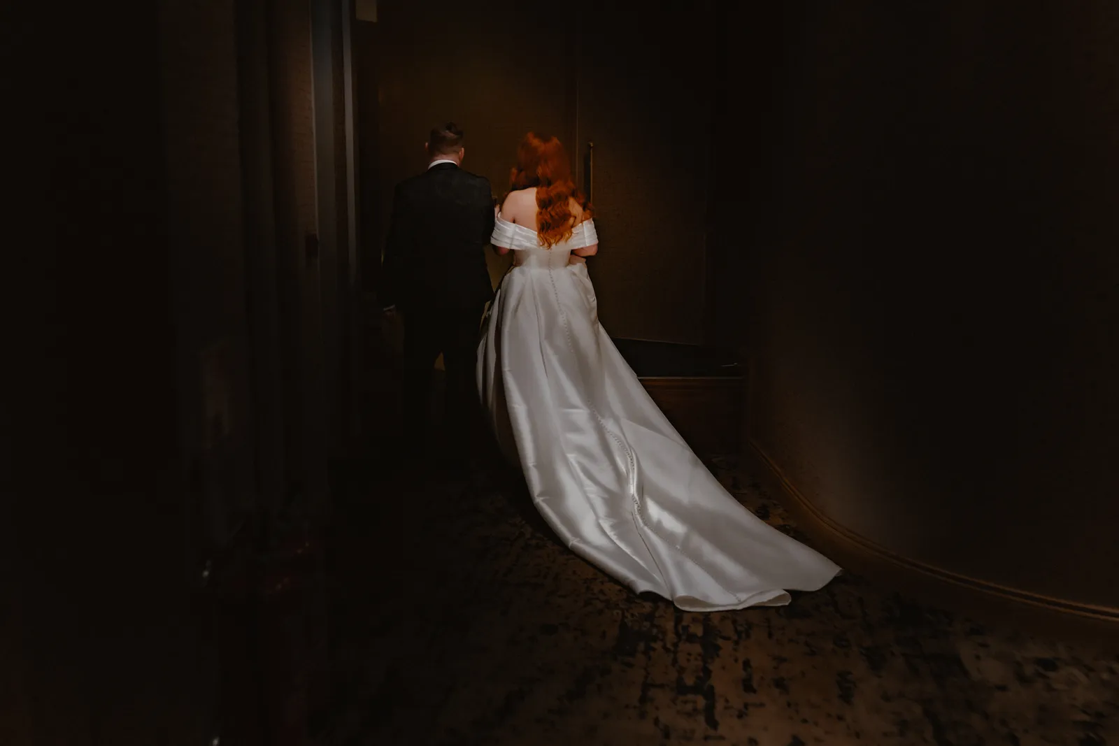 Sarah and her dress against a dark interior