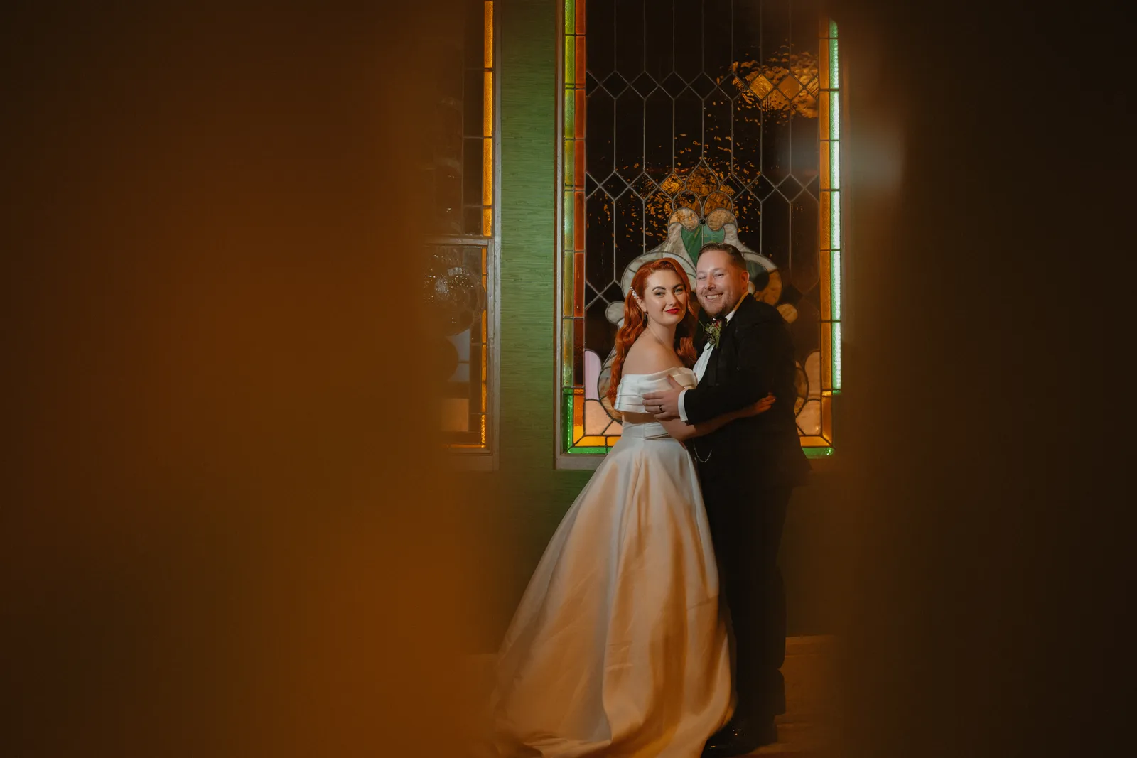 Sarah and Mark beside stained glass