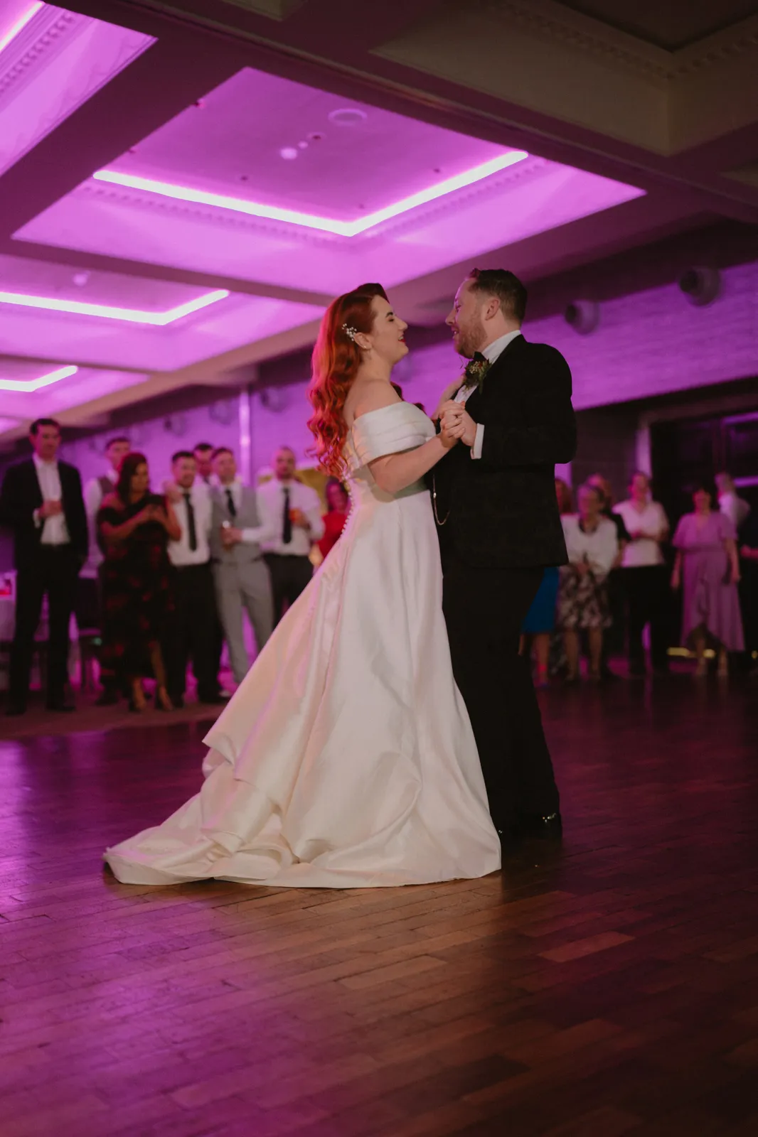 Sarah and Mark dancing beneath purple lights