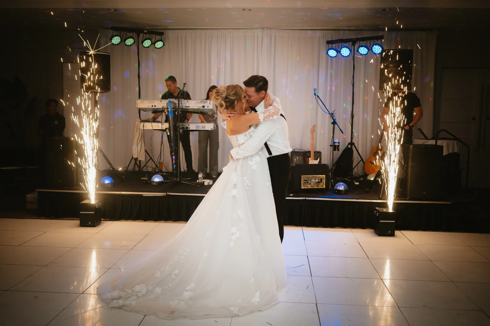 The couple dance beside stage fountains